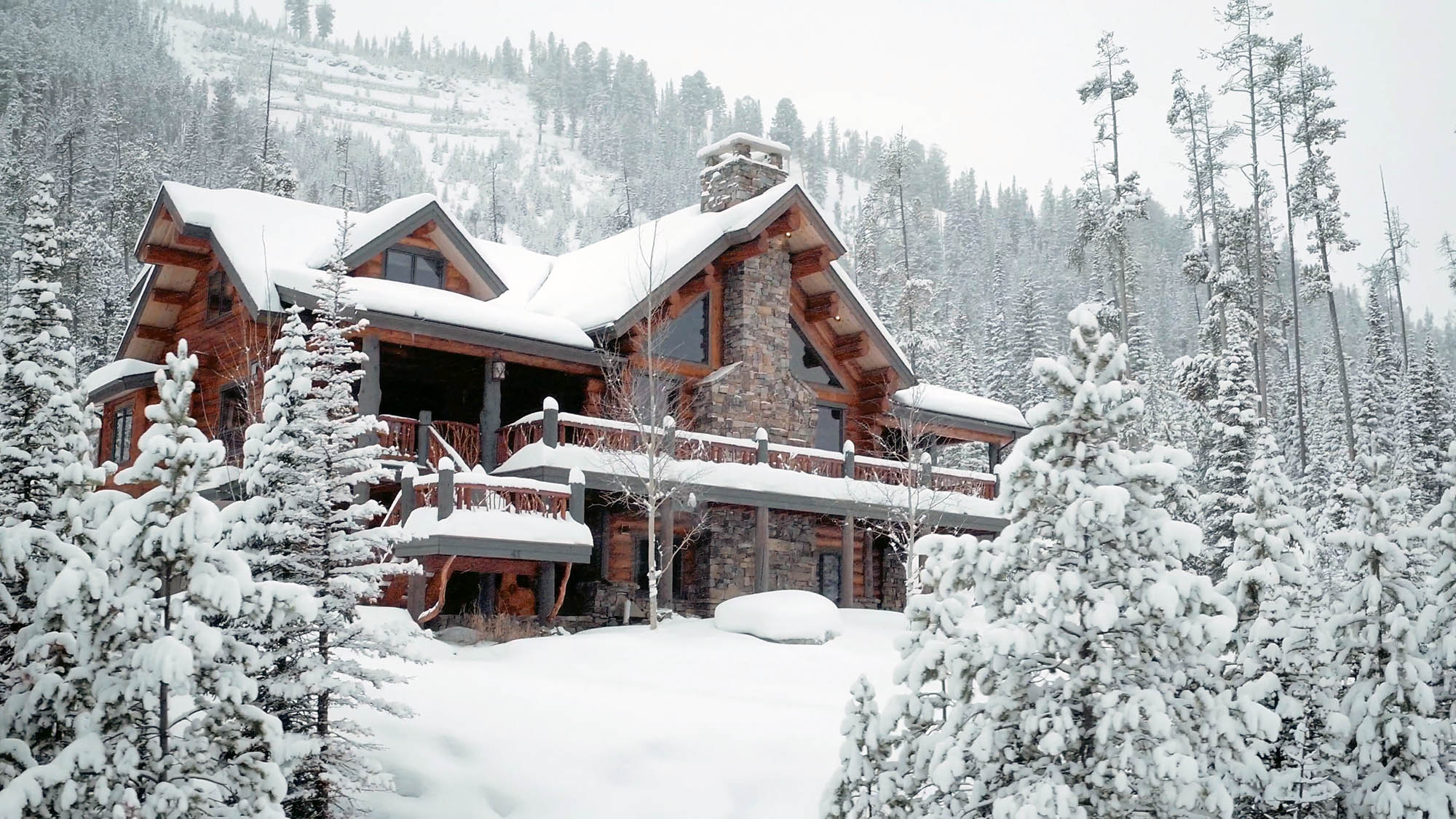 A mountain home surrounded by snow-laden evergreen trees